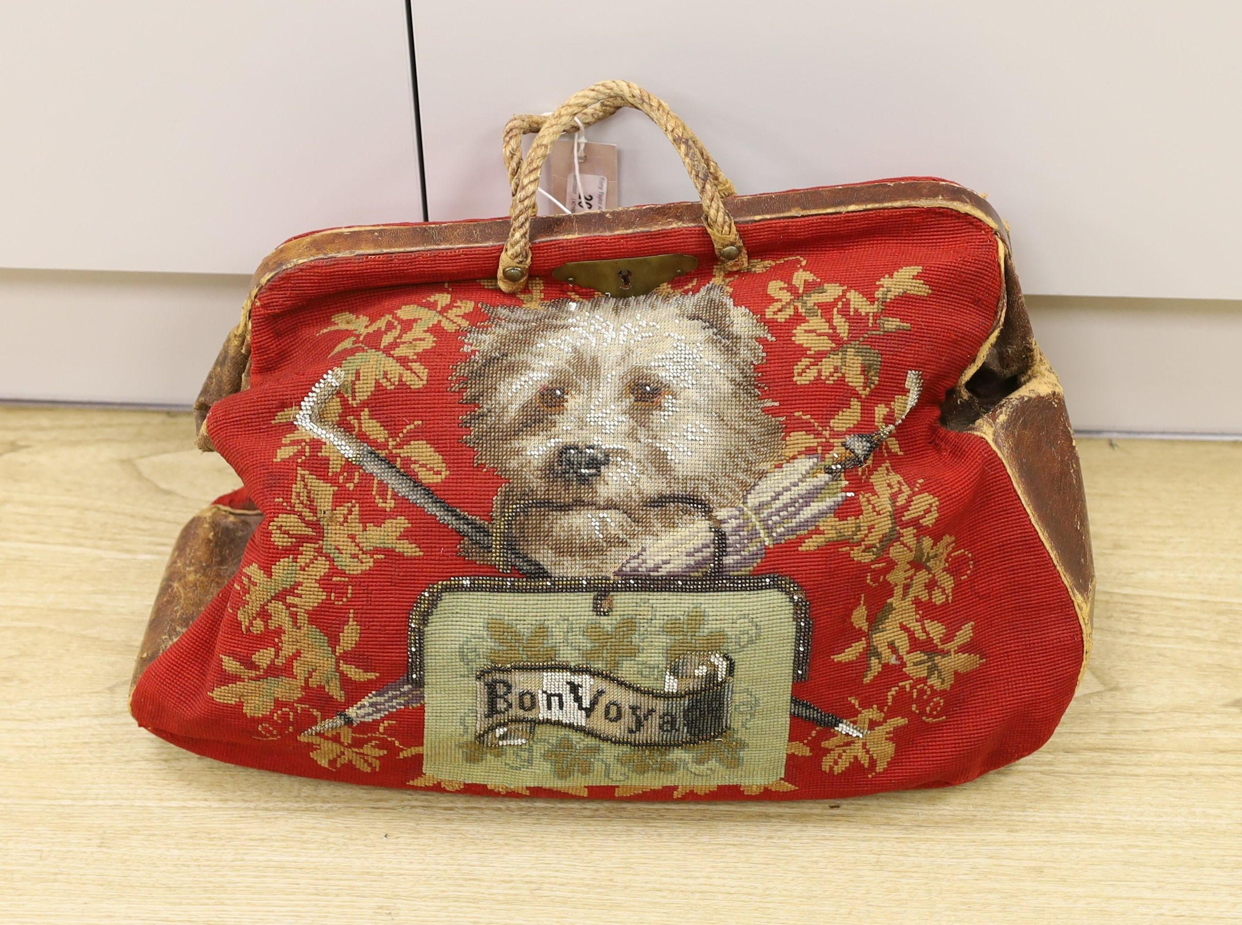 A 19th century Berlin beadwork and leather travel bag, designed one side with a King Charles Spaniel and other with a Terrier and message ‘Bon Voyage’, 46 cms wide x 35 high.